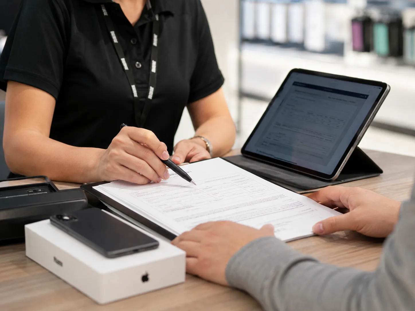 Retail employee completing a telecom contract with a customer